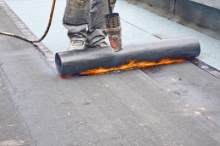 Ouvrier posant une membrane élastomère - toiture d'un multiplex