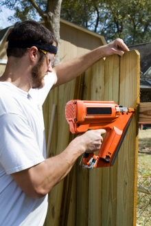 Ouvrier effectuant la réparation d'une clôture en bois traté région Vaudreuil-Dorion